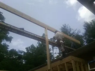 Carpenter setting a ridge beam over a new addition frame — Ice Dam Removal by Roofing Brothers in Campbell